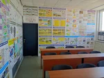 Інтер'єр навчального класу філії автошколи «Антарес» (Харків, проспект Ювілейний, 56). Вигляд на ряди нових парт із сірими стільцями. Справа на стіні деталізований плакат із дорожніми знаками України (категорії знаків, таблички).